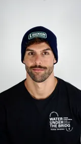 Gorro tipo beanie de punto color azul marino con parche bordado de la marca Duxon en la parte frontal.