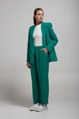 Pantalón de vestir verde esmeralda con pinzas, corte recto y bolsillos laterales.