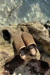 Sandalias tipo zueco con capellada tejida en cuero con rafia.