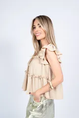Blusa color beige con escote cuadrado, mangas cortas con volados y corte escalonado con volados.