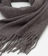 Bufanda de tejido suave con diseño de franjas en los extremos y terminación con flecos.