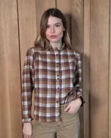 Camisa de algodón con estampado de cuadros en tonos marrones y beige. Presenta cuello alto con volados, cierre frontal con botones y mangas largas con puños con volados.