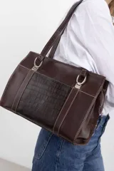Cartera tipo shopper de cuero genuino marrón con panel central de textura símil cocodrilo y herrajes metálicos plateados.