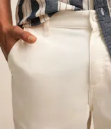 Bermuda básica en sarga de algodón color salmón, de corte recto con trabillas en la cintura, cierre de botón y cremallera, y bolsillos.