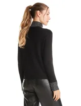 Polera de tejido soft color negro, con cuello alto y puños decorados con apliques de strass. Presenta un diseño de manga larga y corte ajustado.
