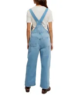 Enterito de jean azul claro, con tirantes ajustables, bolsillo tipo canguro en el pecho y bolsillos laterales y traseros.