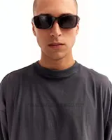 Remera gris oscuro de manga corta con silueta oversized y cuello redondo.