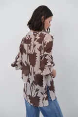 Camisa de manga larga con estampado floral en tonos marrones y negros, cuello mao y cierre frontal parcial con botones.