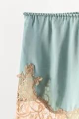 Shorts de satén color turquesa con cintura elástica y bajo decorado con aplicación de encaje en tono contrastante.