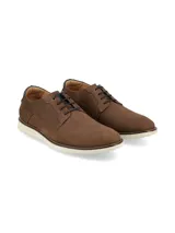 Zapato acordonado de cuero color marrón, con suela de goma blanca tipo deportiva.