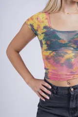 Remera corta de mesh con estampado abstracto en tonos violeta y rosa, de mangas cortas y cuello cuadrado.