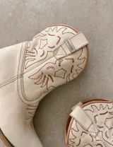 Bota corta estilo western de cuero color marrón, con taco cuadrado de 5 cm y diseño clásico. Presenta un acabado desgastado en la puntera y el talón.