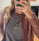 Collar corto con cuentas de piedra cornalina ágata y dije colgante de bronce con forma de sol.