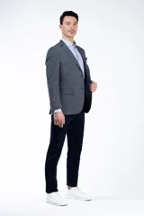 Blazer gris de lino con corte entallado, solapas de muesca, cierre de dos botones, dos bolsillos delanteros con solapa y un bolsillo en el pecho.