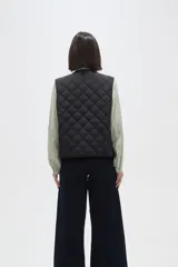 Chaleco acolchado de color negro con diseño de rombos, cierre frontal con botones metálicos a presión y dos bolsillos delanteros aplicados.