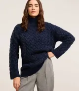 Suéter azul marino de punto trenzado con cuello alto y mangas largas.