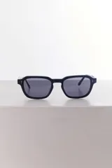 Lentes de sol con marco negro y patillas color carey.