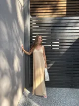 Vestido largo color beige, de viscosa, con tirantes finos, escote en V y aberturas laterales en la falda.