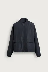 Sobrecamisa regular fit color negro, confeccionada en tejido técnico repelente al agua, con cuello y puños de canalé, bolsillos frontales tipo parche con solapa y cierre de cremallera.