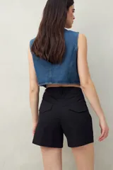 Short color verde militar, de tiro medio, con bolsillos delanteros y traseros.