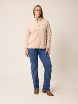 Canguro de sherpa color bordó, con cuello alto y cierre frontal parcial. Presenta un bolsillo con cierre en el pecho y bolsillos laterales, confeccionado en tejido de textura suave y abrigada.