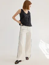 Pantalón de lino azul con corte palazzo y vivos a contratono color beige en los laterales.