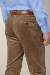 Pantalón de pana de corte clásico, color tostado, con cierre de botón y cremallera, bolsillos laterales y traseros.