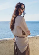 Blusa de lyocell y viscosa con estampado de rayas finas, cuello redondo, manga larga abotonada y detalle cruzado en la cintura.