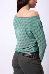 Top de microtul estampado con diseño a cuadros en tonos verde y azul, con escote asimétrico y mangas largas.