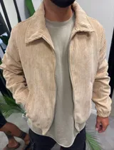 Campera de pana color beige con cierre frontal completo, cuello clásico y puños elásticos. Presenta un diseño de textura acanalada con bolsillos laterales.