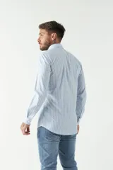 Camisa de manga larga para hombre, color azul claro con microestampado de cuadros. Presenta un corte slim y cuello abotonado.