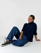 Pantalon de denim azul de corte holgado, con cintura elástica y puños ajustables con cordones en los tobillos.