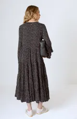 Vestido midi negro con corte en la cintura y falda amplia con volados.