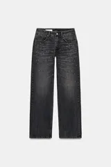 Jeans de tiro bajo y corte recto, confeccionados en denim color gris oscuro con efecto lavado. Presentan cinco bolsillos y están decorados con aplicaciones de strass multicolor en diferentes formas y tamaños en la parte frontal. Cierre frontal con cremallera y botón metálico.