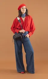 Riñonera de cuero sintético azul con textura croco, cierre superior y correa bandolera de cuero sintético negro con detalles en blanco.