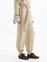 Babucha de corte amplio confeccionada en una mezcla de viscosa y seda con estampado floral pequeño. Presenta cintura elástica, puños ajustados en los tobillos y vivos laterales en contraste.