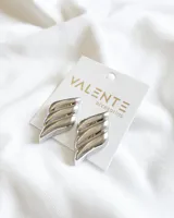 Par de aros colgantes plateados con forma de ala estilizada y diseño acanalado.