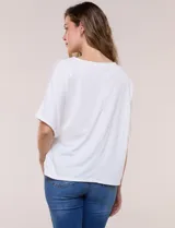 Remera blanca de manga corta, confeccionada en mezcla de modal, con diseño fluido y detalle de lazo ajustable en el lateral.