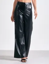 Pantalón de eco cuero negro, marca Elan, con pretina, cierre y broche interno. Presenta costura frontal en la pierna y bolsillos simulados en la parte trasera.