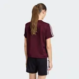 Remera Adidas de la línea Originals, confeccionada en tejido tricot color bordó. Presenta cuello redondo, corte holgado y las icónicas tres rayas de la marca en los hombros. Incluye el logo del trifolio bordado en el pecho.
