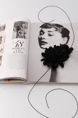 Gargantilla con cordón fino negro y aplique de dos flores grandes de tela color negro.