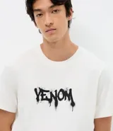 Remera de algodón color blanco, con cuello redondo y manga corta. Presenta una estampa frontal con el logo de Venom en estilo graffiti negro.