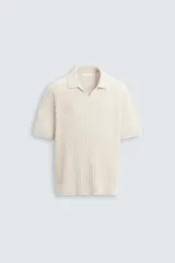 Polo de punto con textura acanalada, cuello solapa con abertura frontal y manga corta. Presenta un diseño de calce regular con terminaciones en rib.