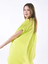 Vestido camisero de corte holgado y diseño asimétrico, con cuello clásico, cierre frontal de botones y mangas cortas con terminación caída.