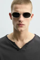 Camiseta de manga larga con corte relajado, confeccionada en algodón. Presenta un cuello redondo amplio con acabado irregular y detalle de botones frontales a tono.