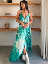 Vestido largo verde con diseño estampado tipo tie-dye y detalles dorados, de corte fluido, un solo hombro y diseño amplio.