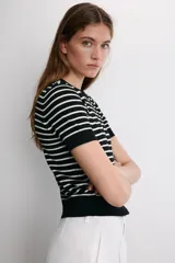 Jersey de punto de manga corta con cuello redondo, a rayas horizontales blancas y negras.