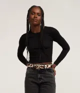 Blusa cropped negra de malla texturizada, con cuello redondo y mangas largas.