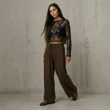Pantalón marrón de tiro medio, corte ancho y fluido, con cintura elástica fruncida y cordón ajustable delantero.