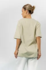 Remerón de algodón color beige, con diseño oversize, cuello redondo, mangas cortas amplias y hombros caídos.